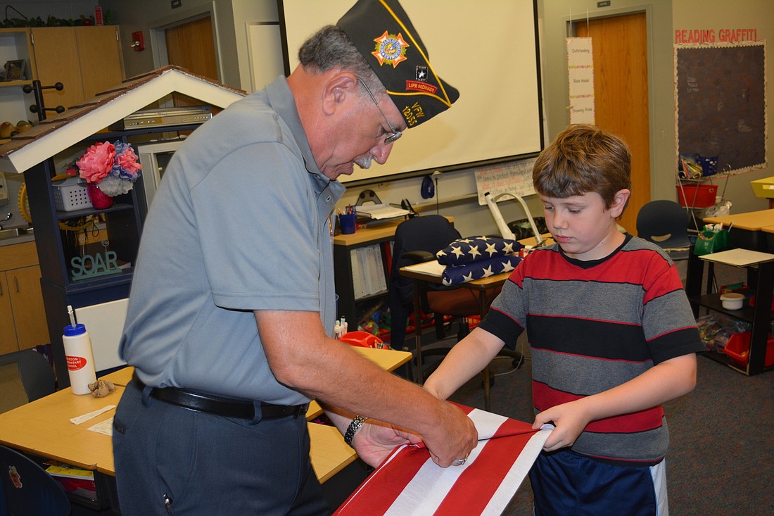 Army veteran Bradley Teitelbalm gives Freedom Elementary third grader Jayden Bell a lesson in folding the American Flag.