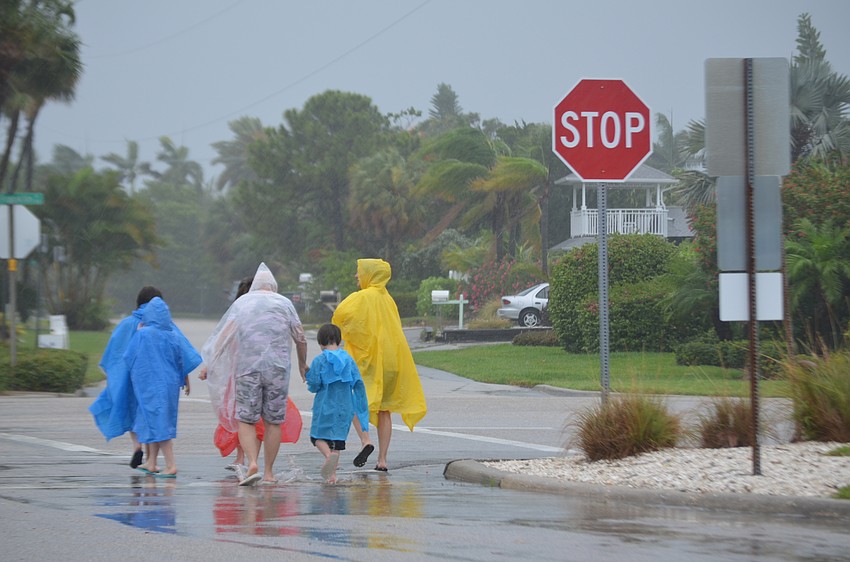 Beachgoers leave Lido Beach as Tropical Storm Colin approaches Florida.