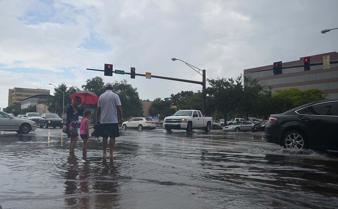 Nicole Fallon (left) waits to cross the intersection of Main Street and Washington Boulevard with her daughter, Corrine Dubois (center) and father, Walt Fallon (right), Tuesday, June 7 in Sarasota, Florida.