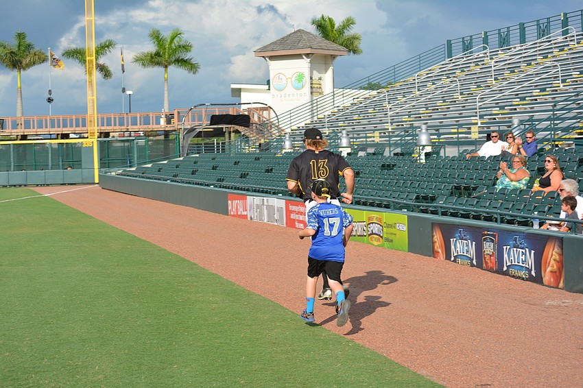 Manatee's Jaxson Withers tries to keep up with Marauders outfielder Michael Suchy before the opening pitch.
