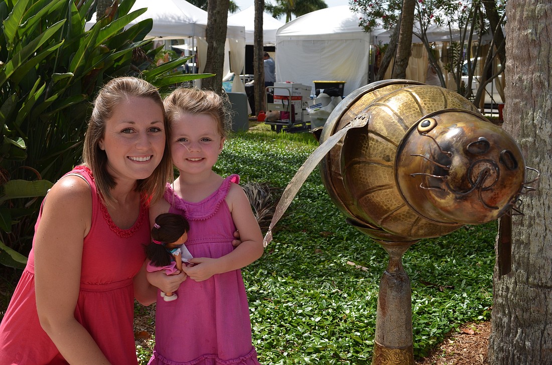 Shayna and Elli Watterson with a manatee statue made by Copper Creations on display at the 2015 St. Armands Craft Festival.