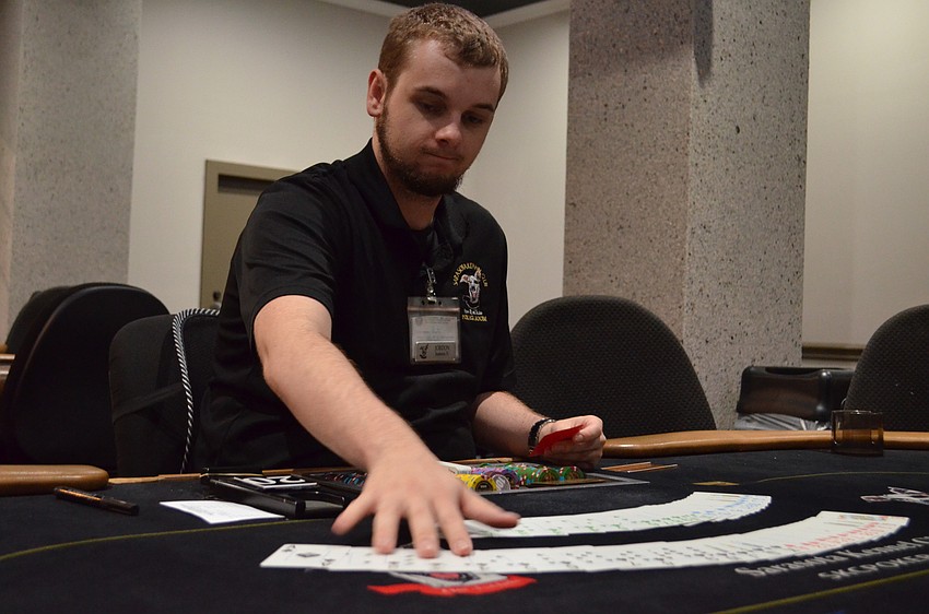 Dealer Jordon Gardner fans out the cards before starting a game of Texas Hold'em.