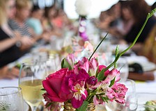 Nearly 40 guests gathered at a banquet table to enjoy a three-course gourmet brunch.