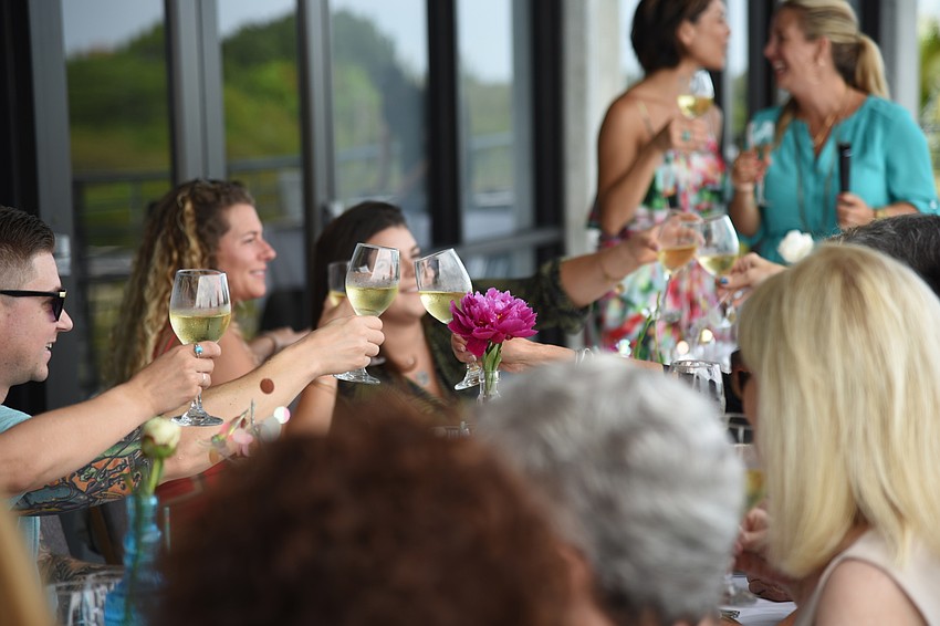 Co-Hosts Courtney Lauderdale and Nikki Logan-Curran raise a toast to friendship with the guests at the event.