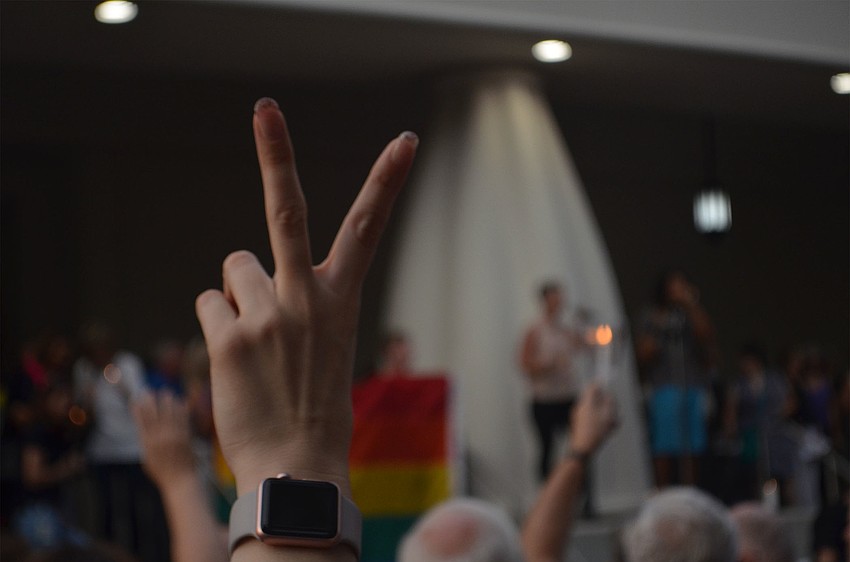 Niki Best holds up a peace sign while Jennifer Real sings 