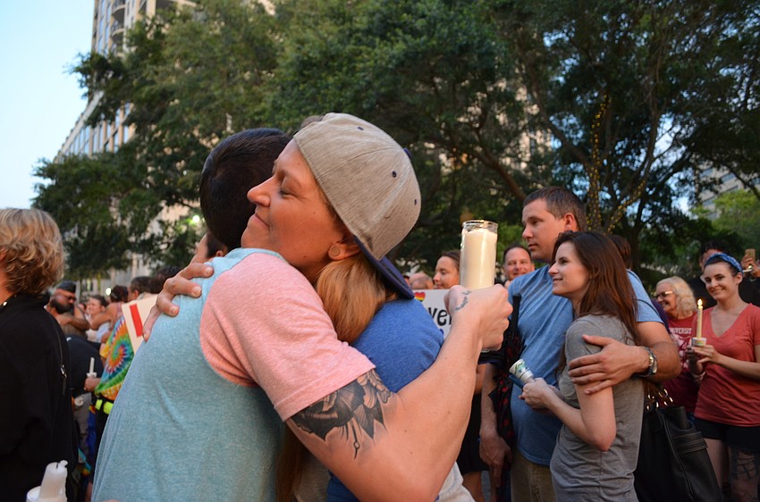 During a speech by Jonathan Hall he encouraged members in the crowd to hug. Douglas Thurston and Miranda Steele embrace one another.