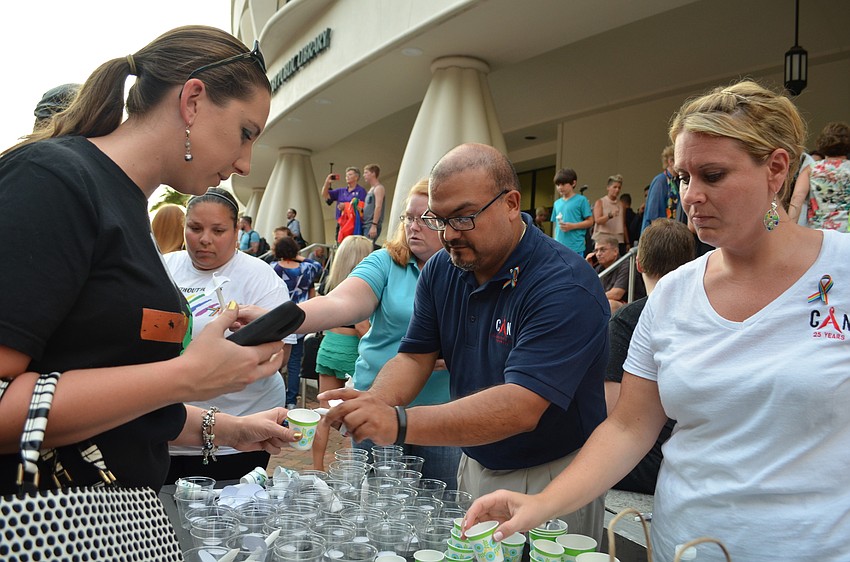 Fernando Vega and Jennifer Lockwood of the Community AIDS Network help distribute candles.