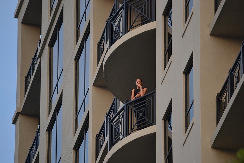 A resident from the Plaza at Five Points watches the vigil from above.