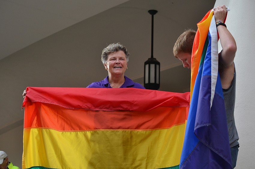 Sarasota Pride Chairman Cindy Barnes and James Godwin help hold up the rainbow flag during the vigil.