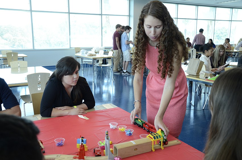 Jennifer Contreras of Braden River High School watches Erica Estep, a LECOM student, show the digestion train. Her lab showed how nutrients travel through the digestive system.