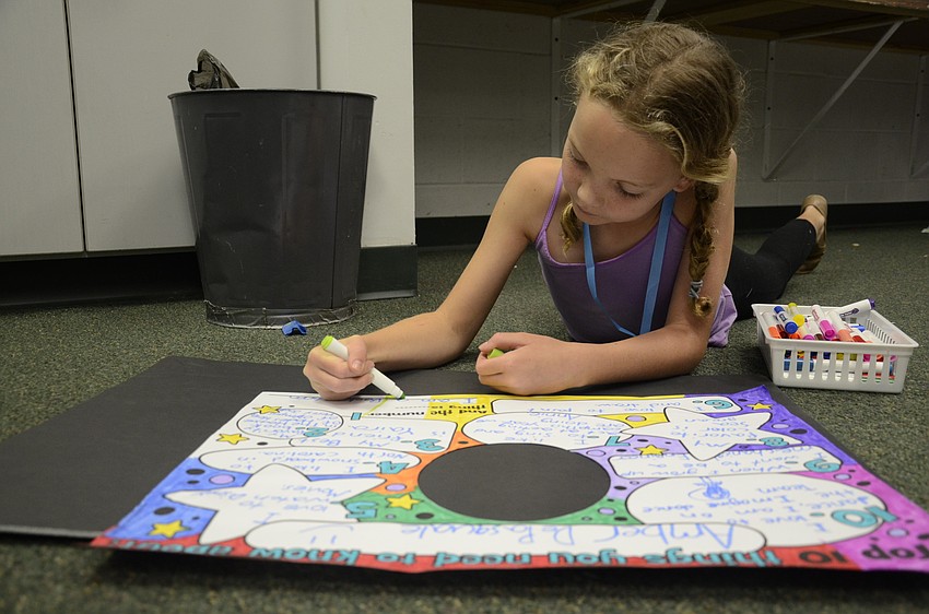 Amber DePasquale of Imagine School decorates a poster.