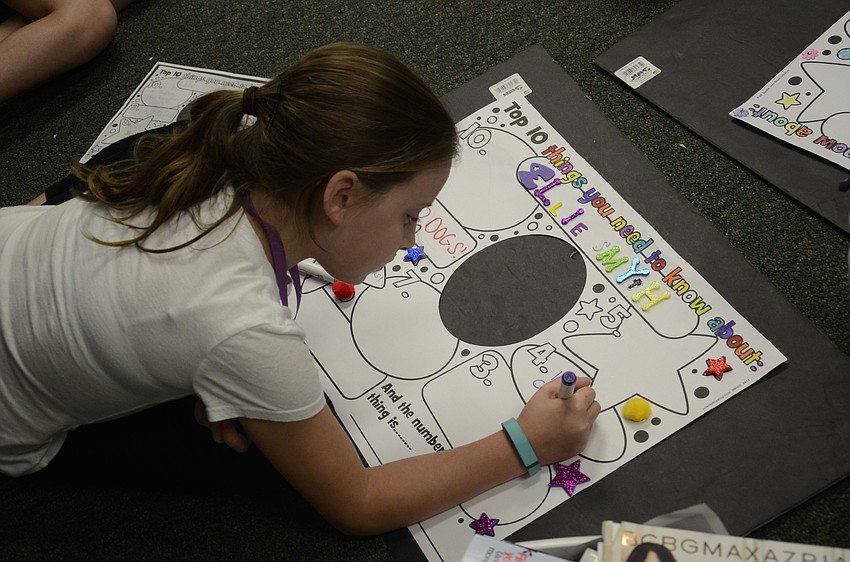 Ellie Smyth of Nolan Middle School tries to decide what to write on her poster, 10 Things about Me.
