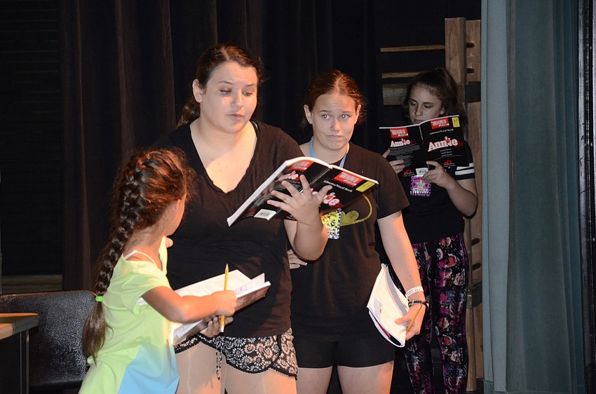 Jordan Cangro, playing Mss Hannigan, Yaira Spears, playing Annie, and Abbi Clark, playing the Ward, act out a scene from Annie, Jr.