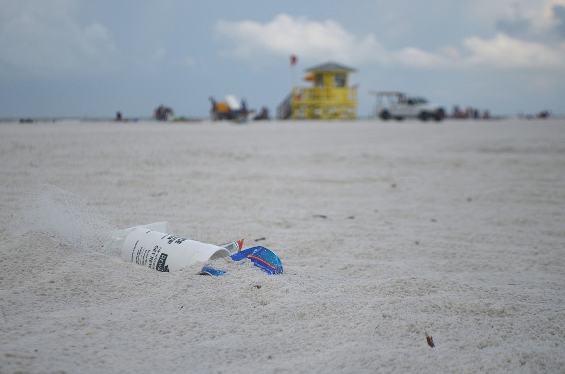 A small pile of trash lays on Siesta Key Beach, half buried in sand on Siesta Key June 17, 2016. Residents and neighborhood groups are organizing efforts to decrease trashÂ in preparationÂ for the incoming Fourth of July crowds.