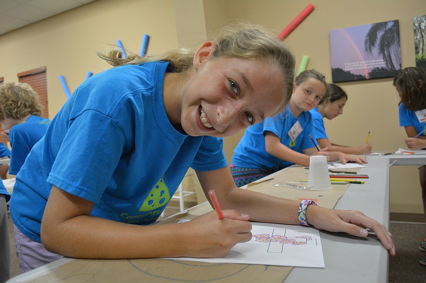 Kate Wright, 10, colors a cross.