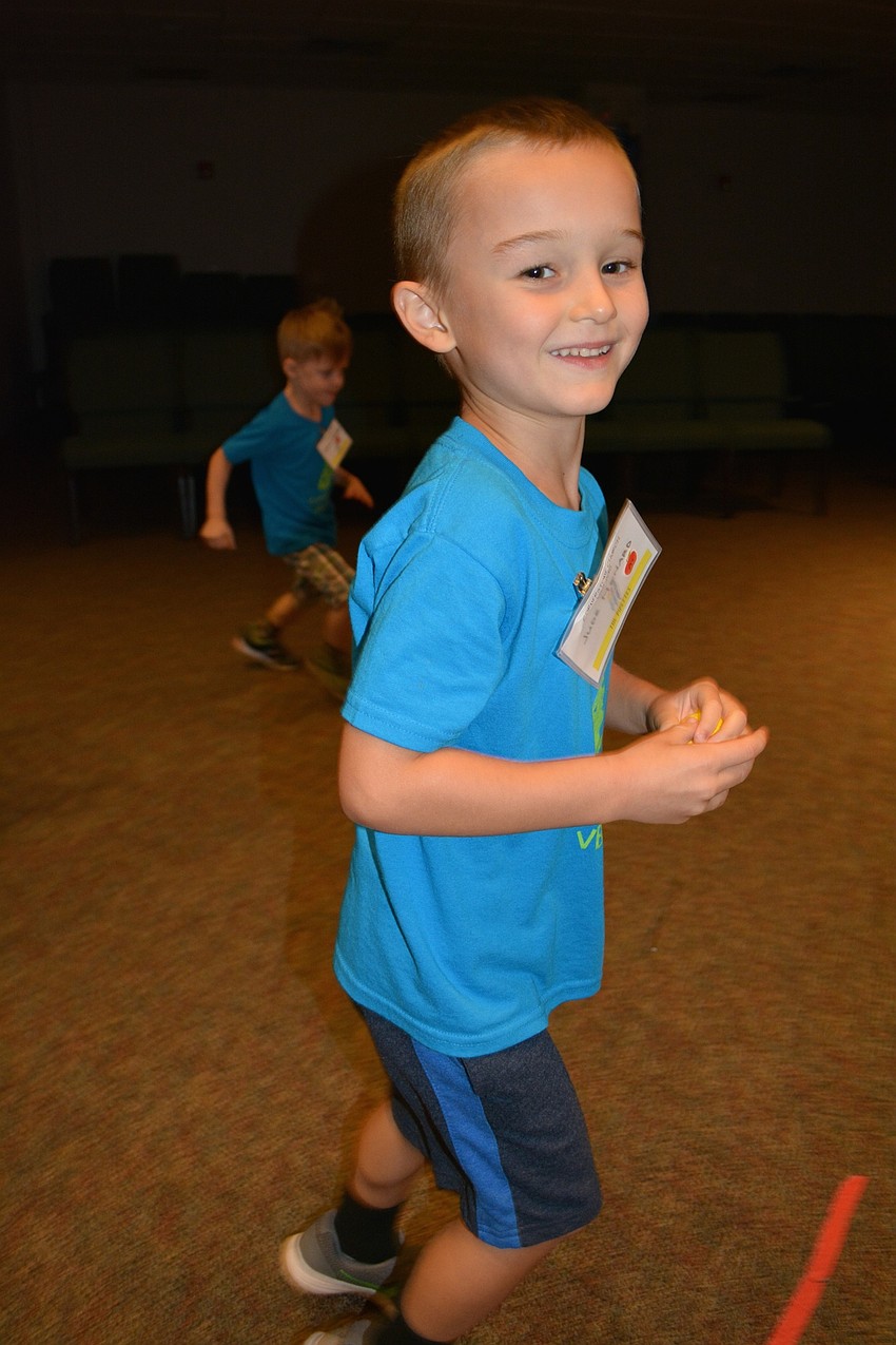 Jude Menard throws electrons (balls) toward the nucleus and tries to hit the moving protons (fellow children).