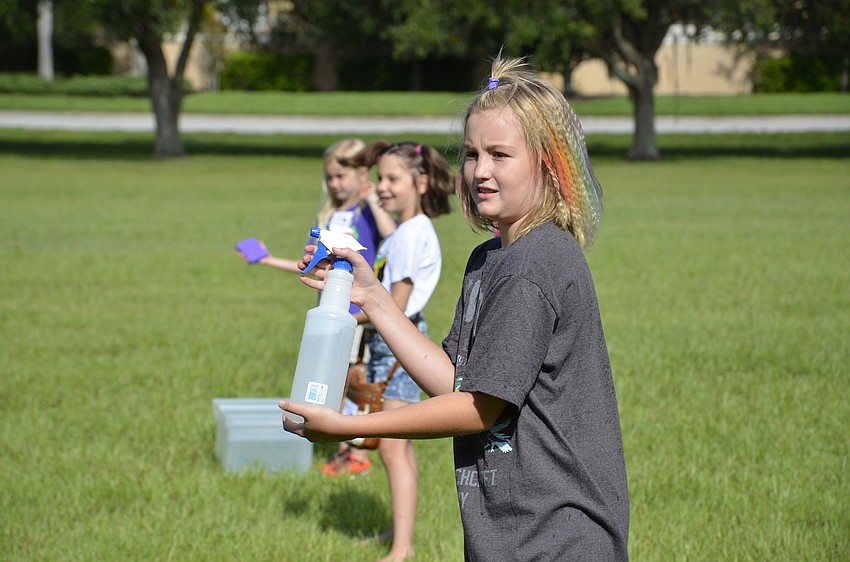 Elizabeth Trumbull sprays at the blindfolded campers.