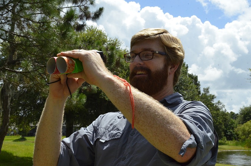 Matt Shick tries to take a photo through the binoculars.