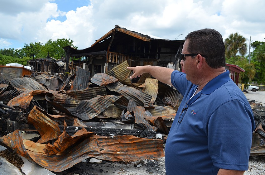 J.R. Garraus surveys the damage to the storage space behind his restaurant five days after a six-alarm fire tore through the property.