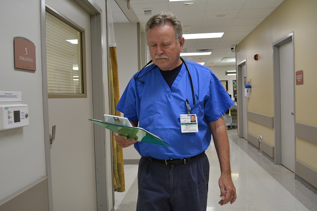 Dr. Dean Christensen looks over a patient chart while walking through Lakewood Ranch Medical Center's emergency room.