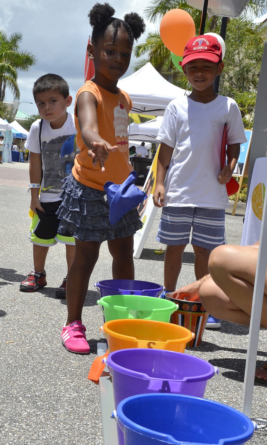 Lyric Perez of Palmetto tries to get the beanbags in the buckets.