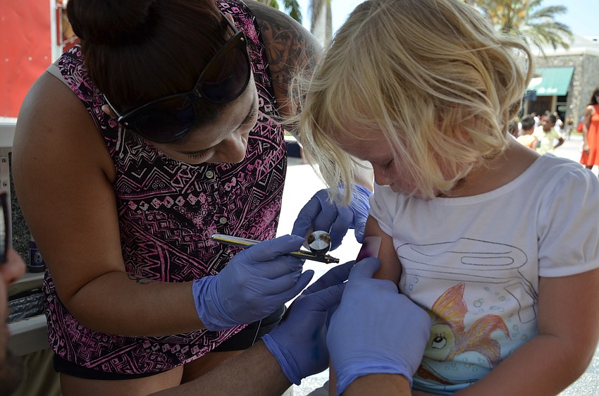 Mia Morgan of Sarasota gets an airbrush tattoo from Breeze Lozano with Easy Breezy Airbrush Tattoo.