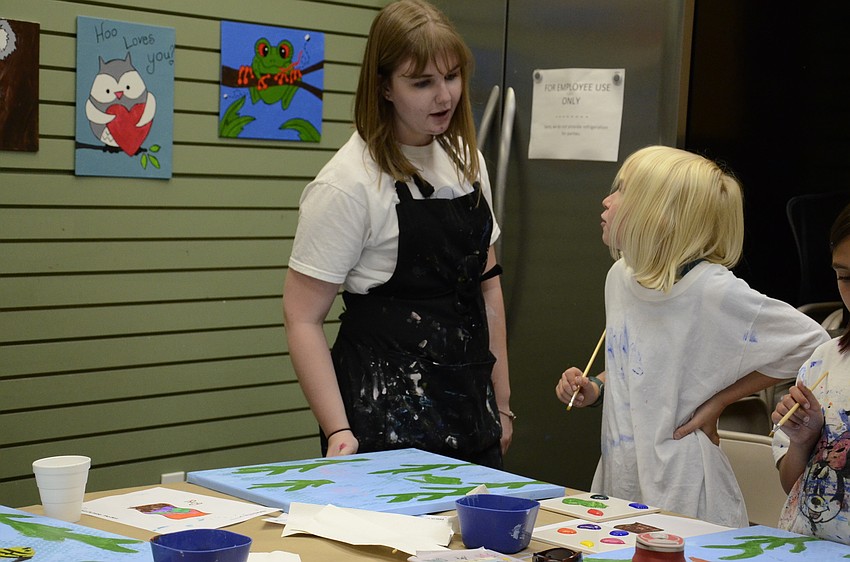 Instructor Nikki Williams talks with Reagan Lesser of Bradenton about putting eyes on the fish.
