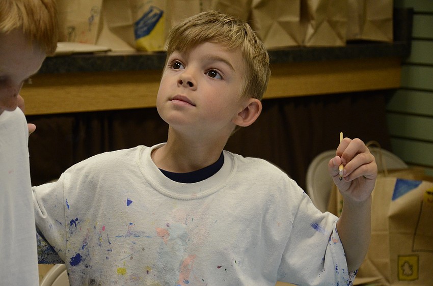 Chaz Campbell studies  the sample painting while creating his own.