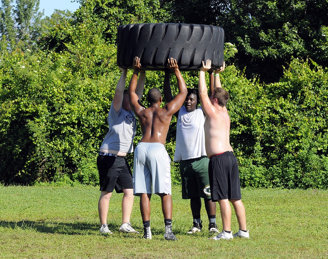 Deqwunn McCobb, AJ Kwiatkowski, Deshaun Fenwick and Taylor Upshaw complete a series of tire presses during a summer conditioning workout.