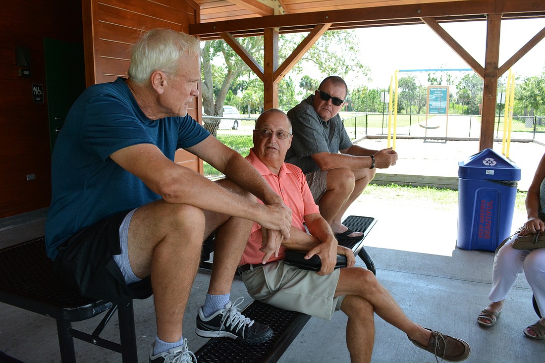 Jake Miklojcik, front, tells Matt DeFano, center, and Bob Walsh, behind, that the redaction of proposal documents requested by Manatee Lost Lagoon prevents taxpayers from learning more about the project.