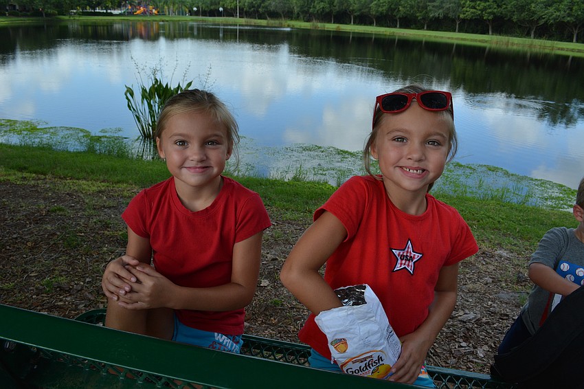 Isabella and Gabriella Leo, both 6, munch on snacks as they watch the parade.