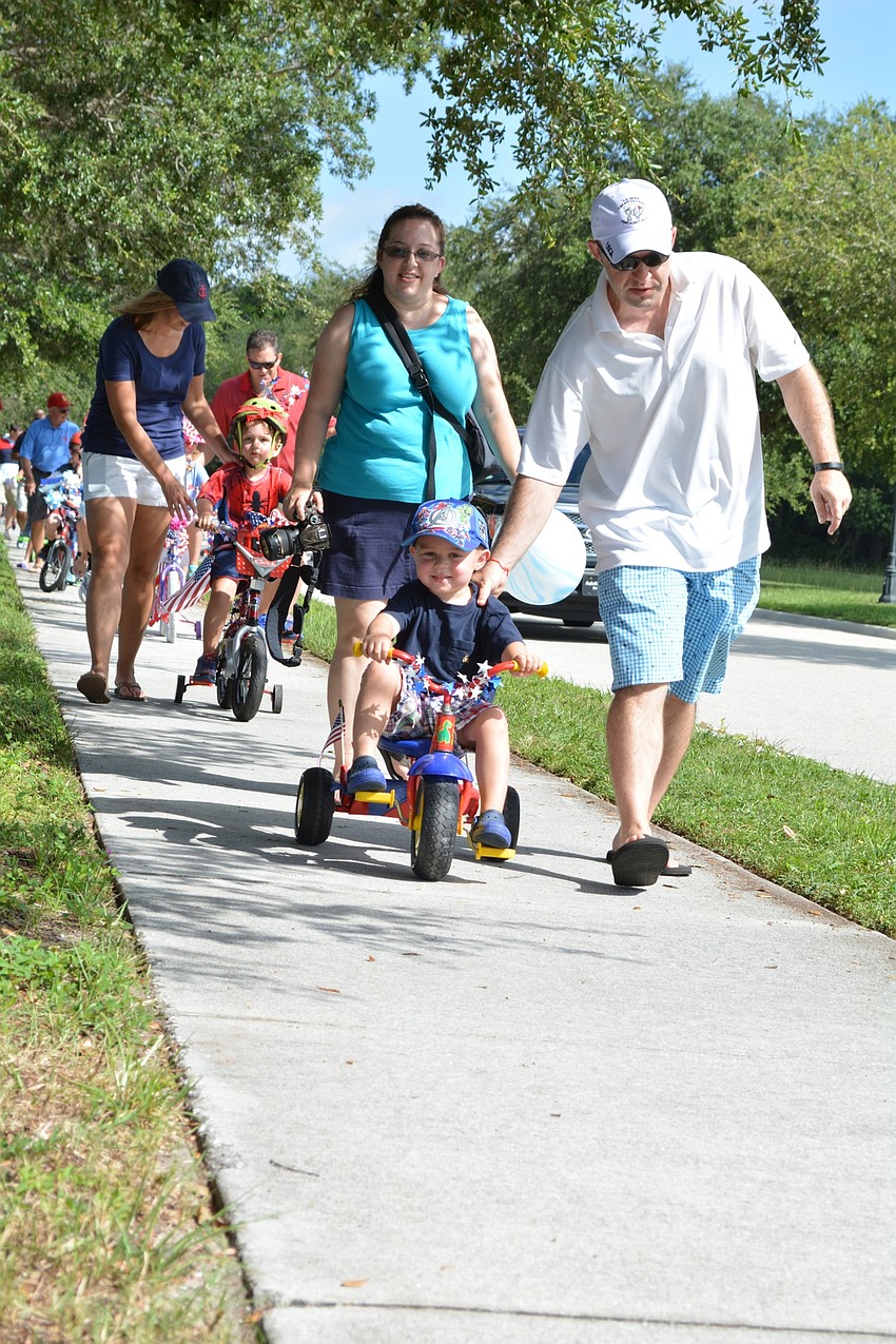 Parker Cujas, 3, bikes his way from the baseball field to the rec center during the GreyHawk Fourth of July Parade.