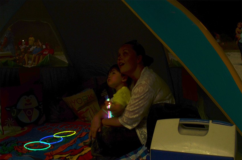 Cape Coral resident Elizabeth Khin holds her two-year-old son, Austin Khin, during Siesta Key's 26th annual fireworks show. It was the first time Austin had seen fireworks.