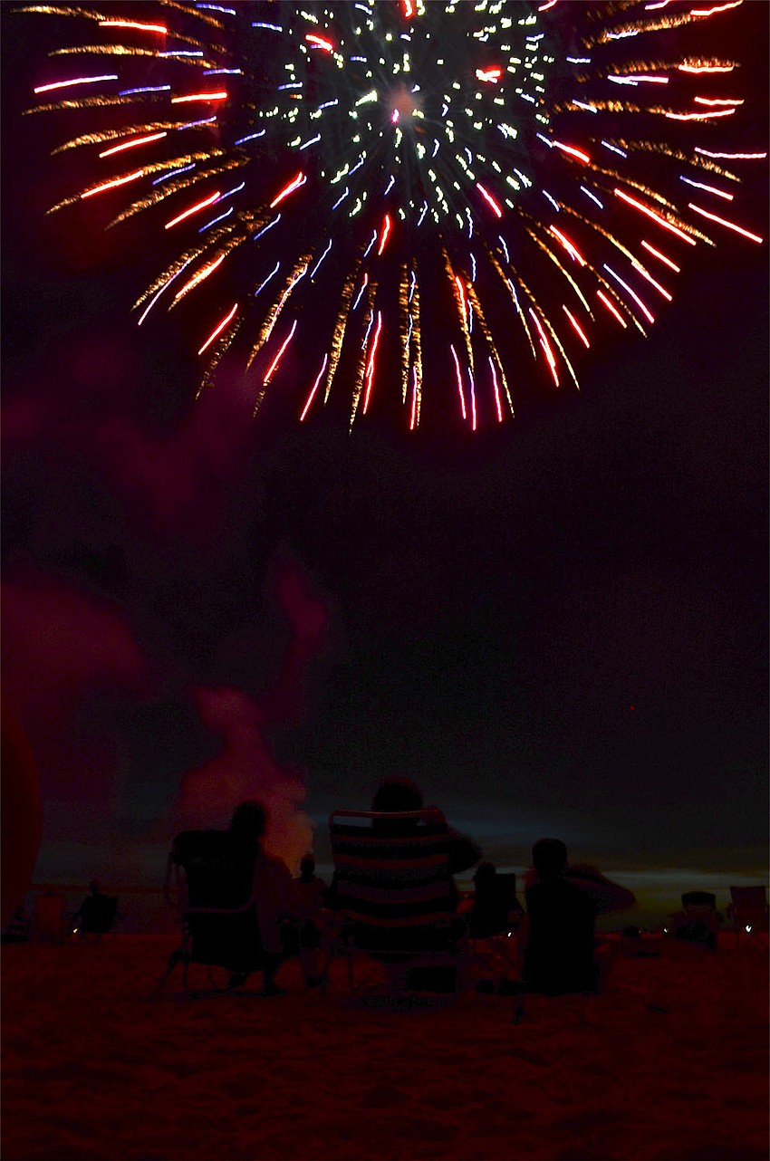 Fireworks explode over a chanting crowd on Siesta Key Beach. Lead pyrotechnician Craig Merrill and his crew lit 2,800 fireworks during the display.