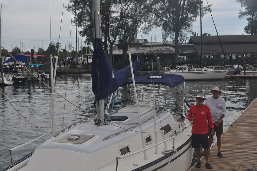 Kim Nichols and Dave Wilson stand next to their boat, Solitude