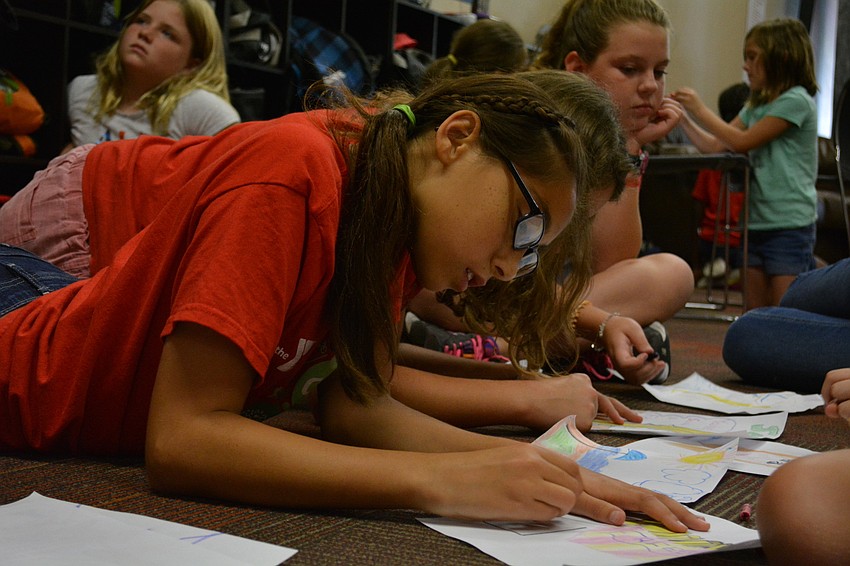Kaylani Pusateri, 11, draws French fries and a drink, as well as a picture of the beach.