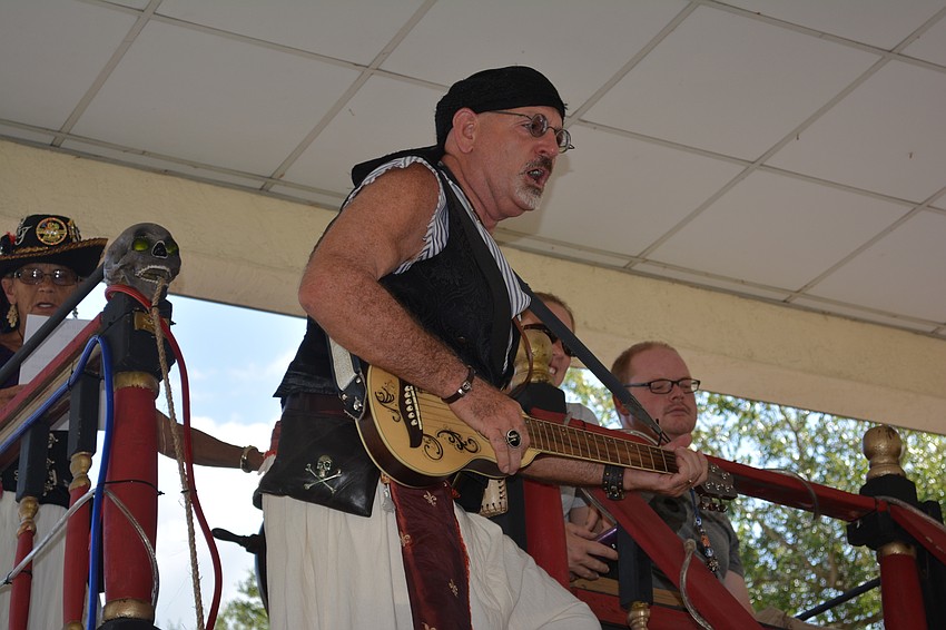 Longboat Key's Larry Wilhelm plays his guitar and sings a pirate song.