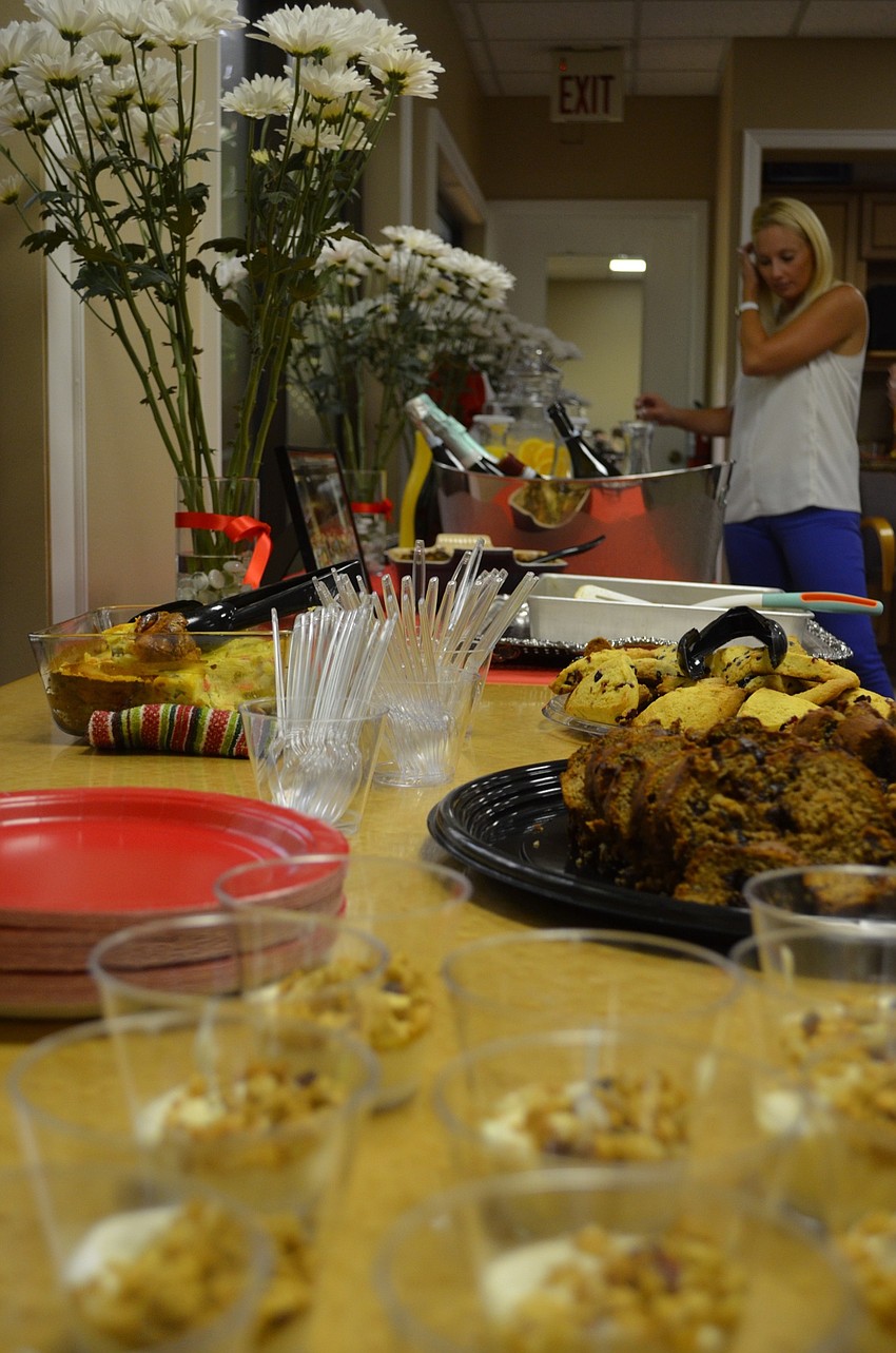 Jeanne Paulus surveys her options at the snack table, which featured mimosas as well as an assortment of casseroles and baked goods made by Junior League members using recipes from the organization’s cookbook.