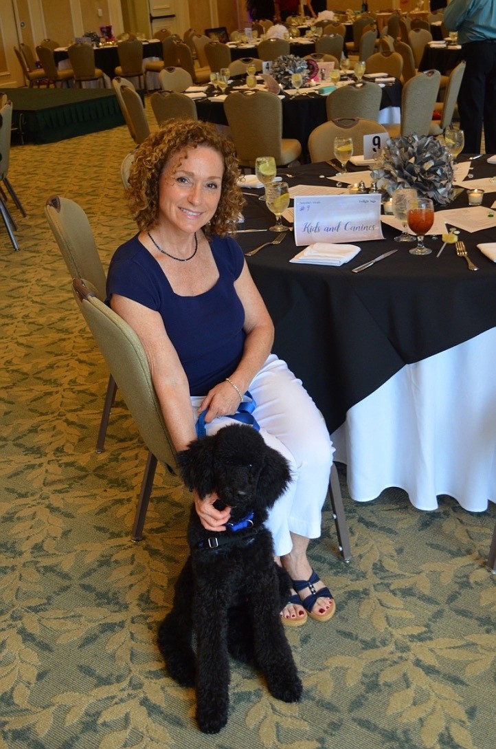 Anita Teney with Ranger, a 4-month-old standard poodle being trained in the Kids and Canines program.