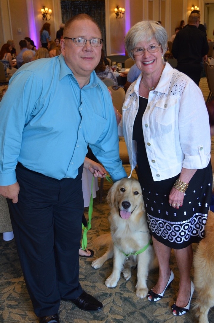 Lynne Dalton and Allan Brown with Porter, a 1-year-old golden retriever training to be a service dog for Kids and Canines.