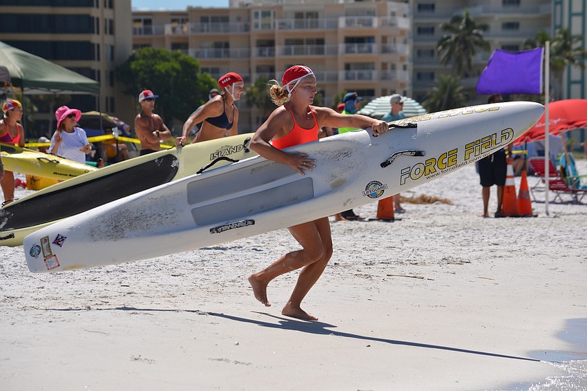 Morgan Sullivan of Clearwater Beach books it into the water during the Paddle Board Rescue.