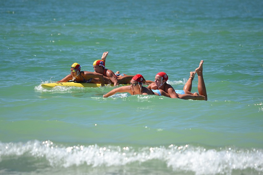 Left, the team from Sarasota County paddles to shore on the second leg of the paddle board rescue.
