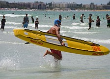 Troy Knopp rushes into the water with his paddle board.