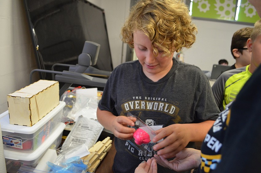 Eitan Campbell pulls the mold off of his sculpture of a face sticking its tongue out.