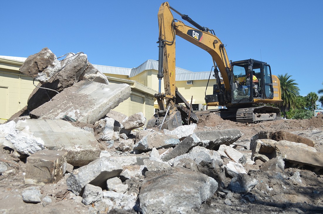 An excavator digs through the rubble of what used to be a gas station car wash next to CBâ€™s Island Outfitters. The new Daiquiri Deck plans to open next to the store in spring 2017.