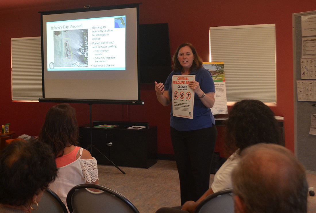 Melissa Tucker of the Florida Fish and Wildlife Conservation Commission presents a mockup of the signs that would be posted around the Roberts Bay Islands if they were designated as a critical wildlife area.