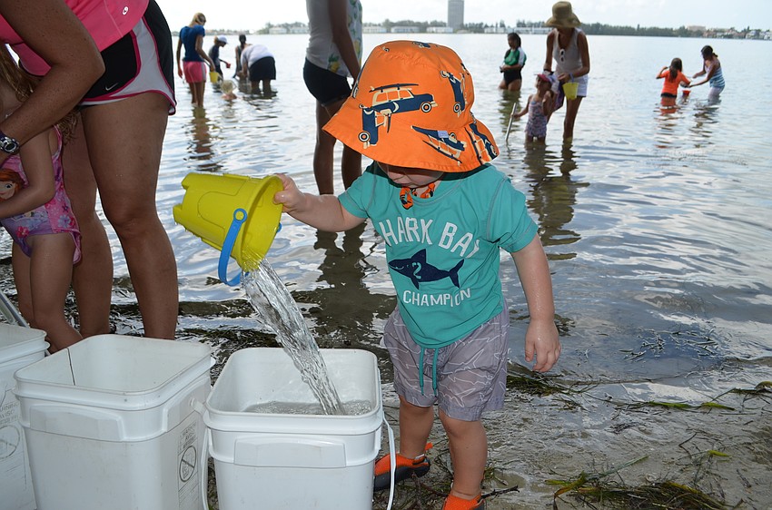 Aydan McCormick dumps his pail of water into one of the wildlife buckets.