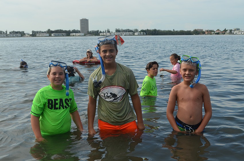 Cooper Couden, 12, David Connerton, 11, and Sterlin Mullins, 10 take a break from snorkeling.