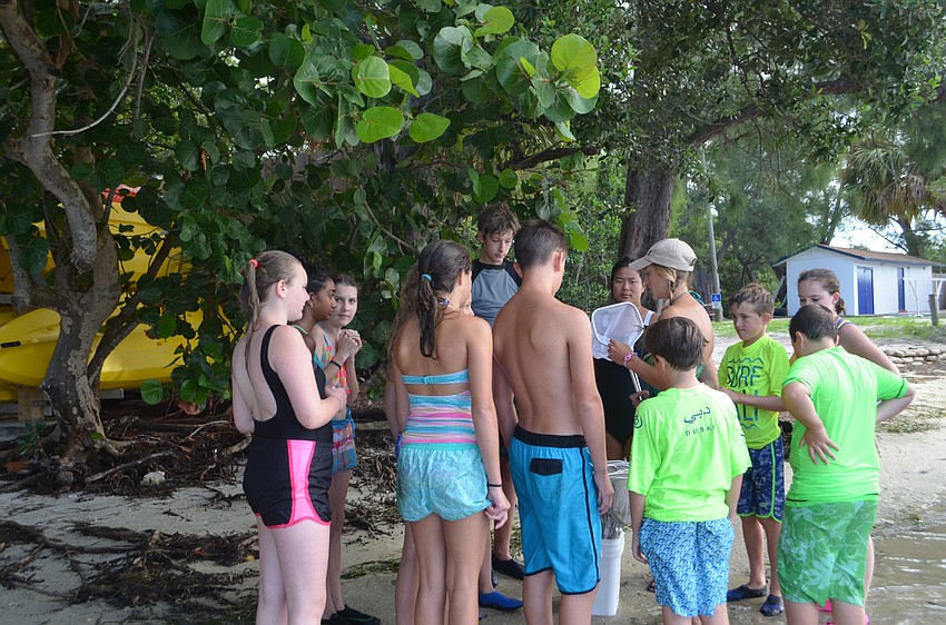 Education intern Meg Simon gives instruction to campers before they skim the bay for marine wildlife.