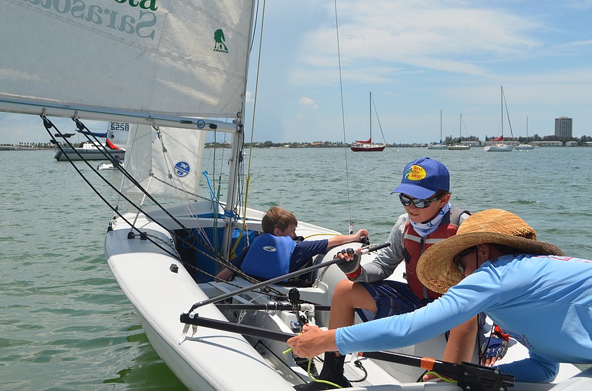 Tate Bridges, 14 and Alex Liebel, 11, get some help from executive director of Sarasota Youth Sailing, Alana O’Reilly.
